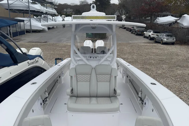 Slide: The Image of 2024 Jupiter 32 FS boat with sleek white interior and dual seating, docked outdoors. - 46