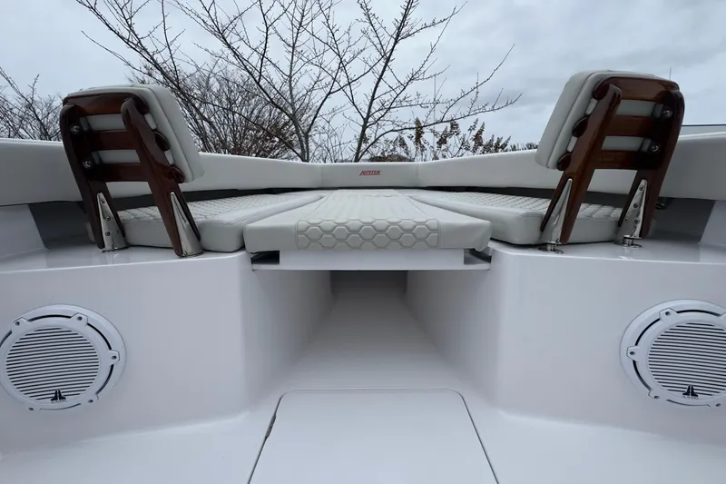 Slide: The Image of 2024 Jupiter 32 FS boat interior with cushioned seating and speakers. - 47
