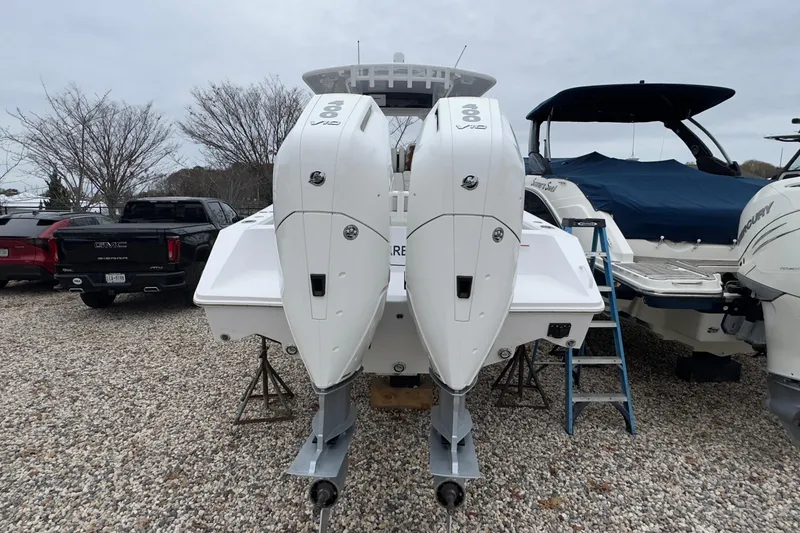 Slide: The Image of 2024 Jupiter 32 FS boat with dual outboard engines on gravel lot. - 5