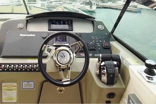 Slide: The Image of Cockpit of 2015 Sea Ray 370 Venture boat with steering wheel and control panel. - 11