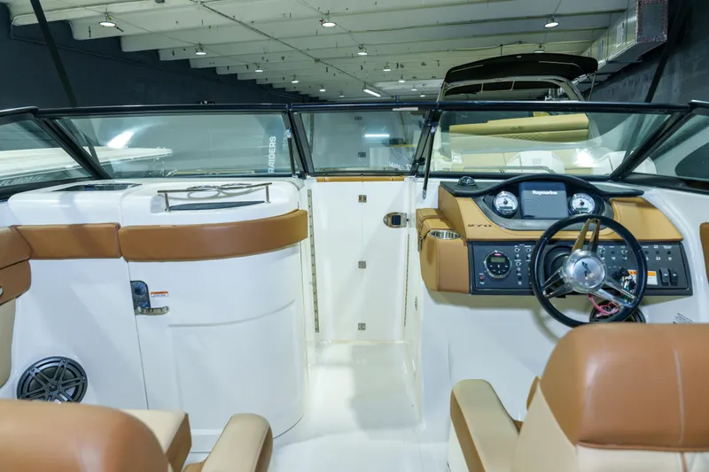 Slide: The Image of 2015 Sea Ray 270 Sundeck interior with tan seating and modern dashboard controls. - 12