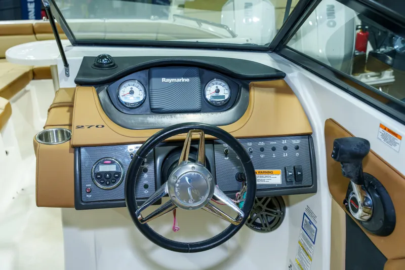 Slide: The Image of 2015 Sea Ray 270 Sundeck dashboard with steering wheel and control panel. - 13