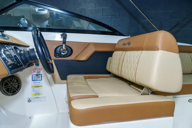 Slide: The Image of 2015 Sea Ray 270 Sundeck interior with tan leather seating and steering wheel. - 15