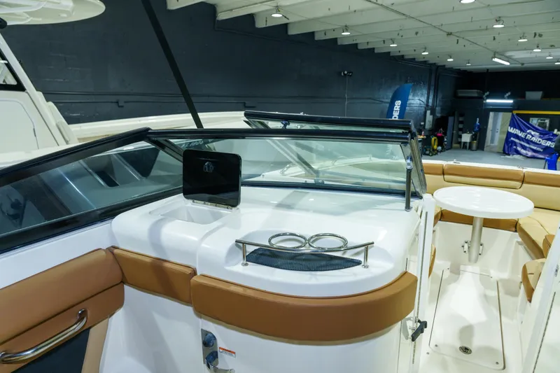 Slide: The Image of 2015 Sea Ray 270 Sundeck interior with seating and table in a showroom. - 19