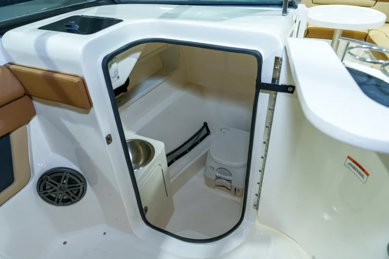 Slide: The Image of 2015 Sea Ray 270 Sundeck interior with compact marine toilet and storage area. - 21