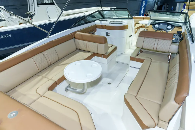 Slide: The Image of 2015 Sea Ray 270 Sundeck interior with beige seating and round table. - 23