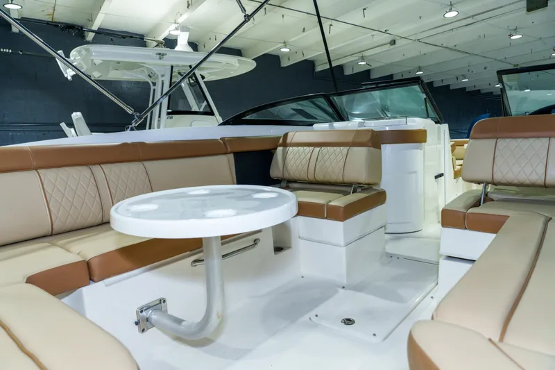 Slide: The Image of 2015 Sea Ray 270 Sundeck interior with tan seating and round table. - 24