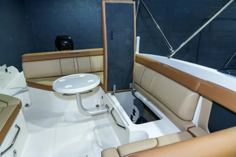Slide: The Image of 2015 Sea Ray 270 Sundeck interior with tan seating and a small table. - 25