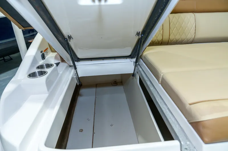 Slide: The Image of 2015 Sea Ray 270 Sundeck storage compartment with open hatch and cup holders. - 29