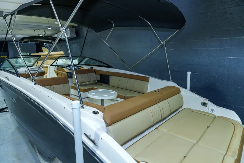 Slide: The Image of 2015 Sea Ray 270 Sundeck boat with spacious seating and canopy in a showroom. - 31