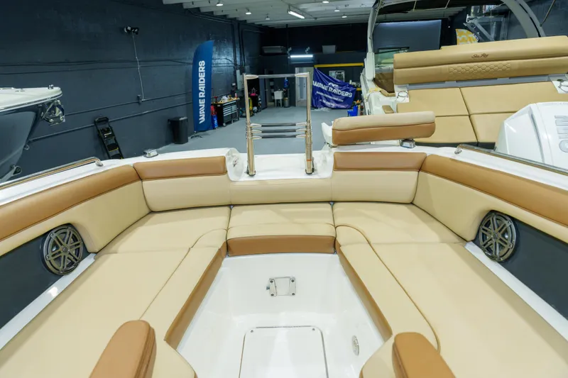 Slide: The Image of 2015 Sea Ray 270 Sundeck interior with tan seating and modern design in showroom. - 9