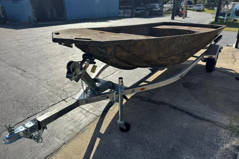 Slide: The Image of 2026 G3 Gator Tough 15 DK boat on trailer, camo design, parked outdoors. - 2