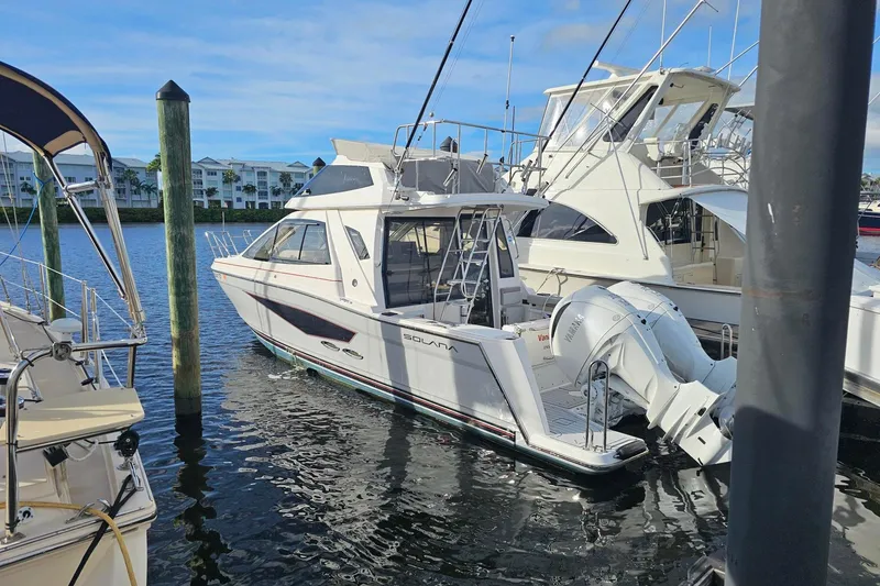 The Image of 2026 Solara S-310 SB boat docked in marina, clear sky, calm water. - 0