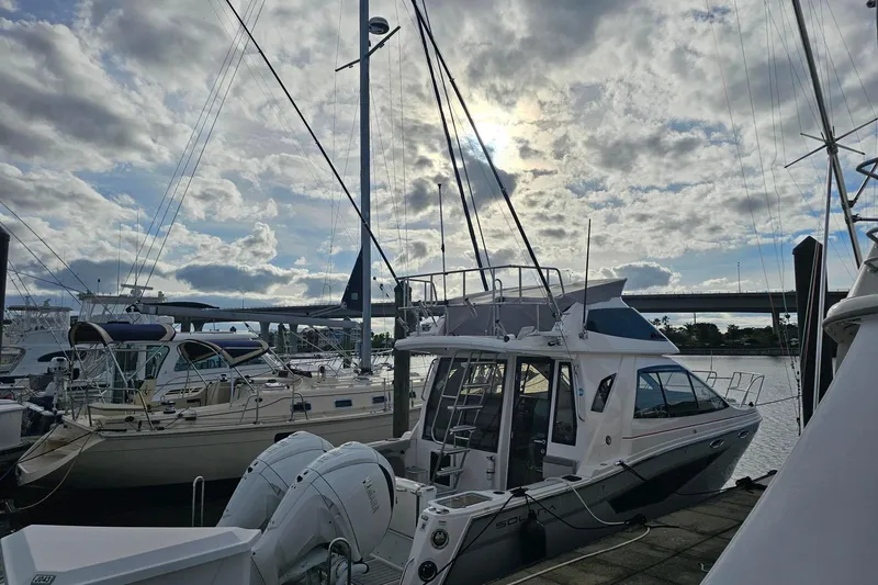 Slide: The Image of Modern Solara S-310 SB yacht docked at marina, cloudy sky backdrop, 2026 model. - 1
