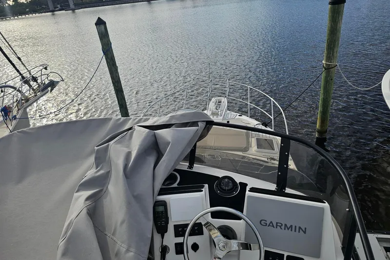 Slide: The Image of 2026 Solara S-310 SB boat docked, featuring Garmin navigation system, overlooking calm waters. - 18