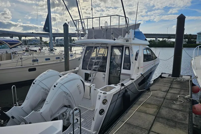 Slide: The Image of 2026 Solara S-310 SB boat docked with dual outboard engines, under a cloudy sky. - 2