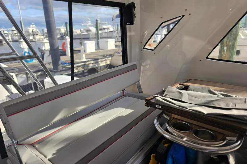 Slide: The Image of Interior of 2026 Solara S-310 SB boat with seating and table, dock view. - 7