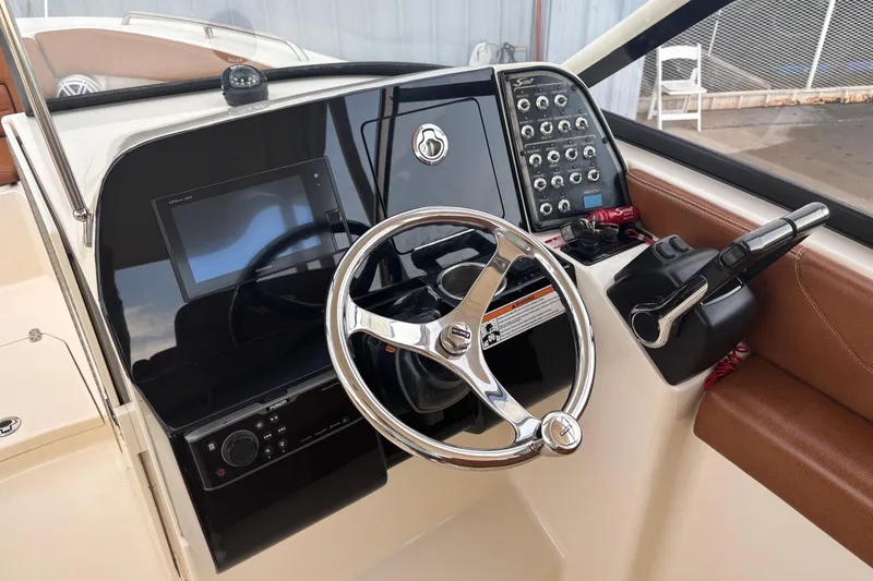 Slide: The Image of 2017 Scout 255 Dorado boat dashboard with steering wheel and control panel. - 16