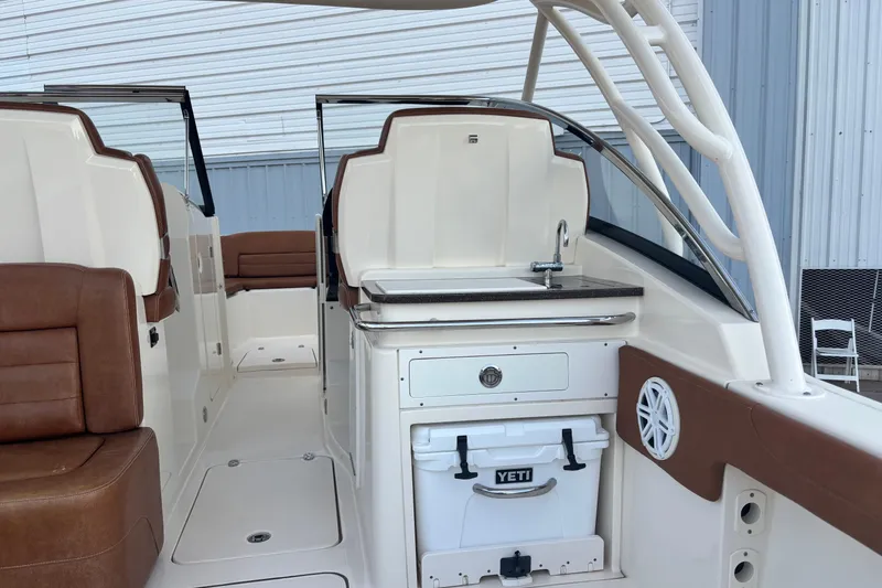 Slide: The Image of 2017 Scout 255 Dorado boat interior with seating, sink, and Yeti cooler. - 17