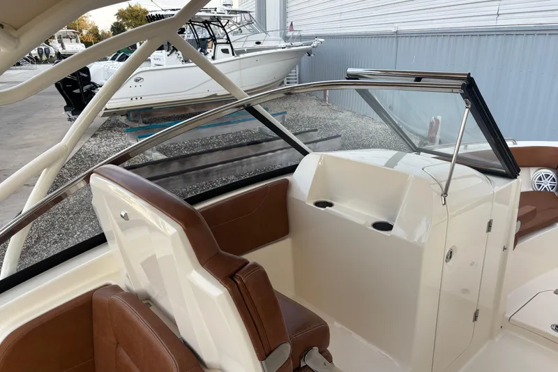Slide: The Image of 2017 Scout 255 Dorado boat interior with brown seating and windshield. - 18