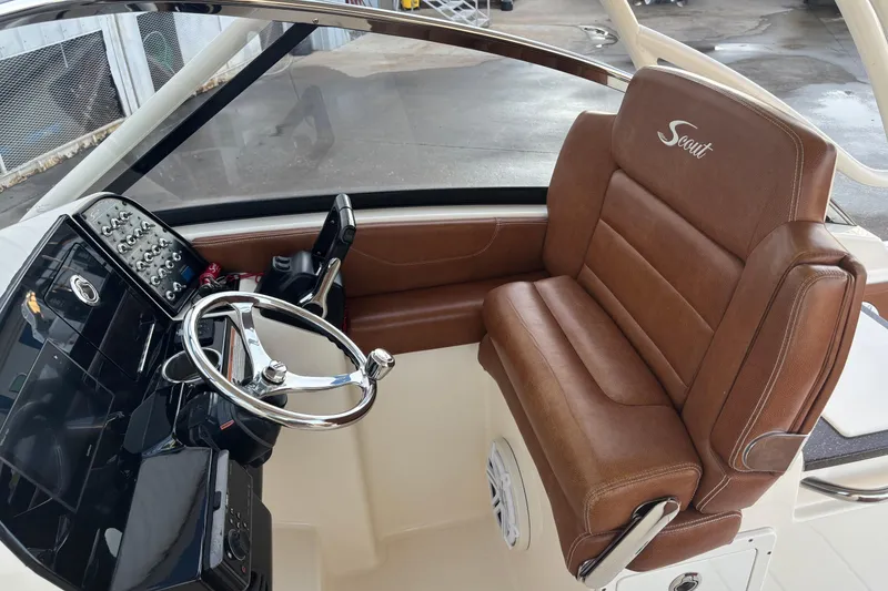 Slide: The Image of 2017 Scout 255 Dorado boat interior with brown leather seating and modern steering console. - 24
