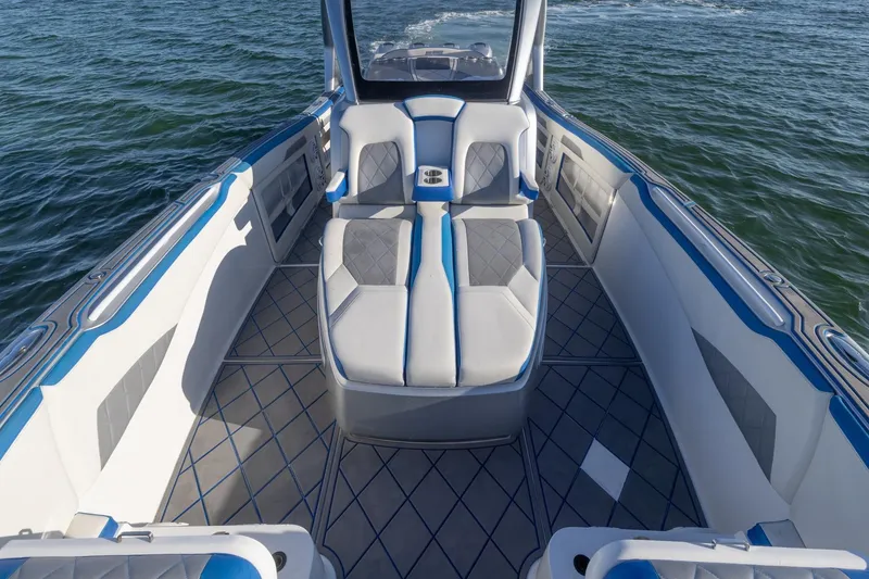 Slide: The Image of 2019 Deep Impact 399 Sport boat interior with blue and gray seating on water. - 14