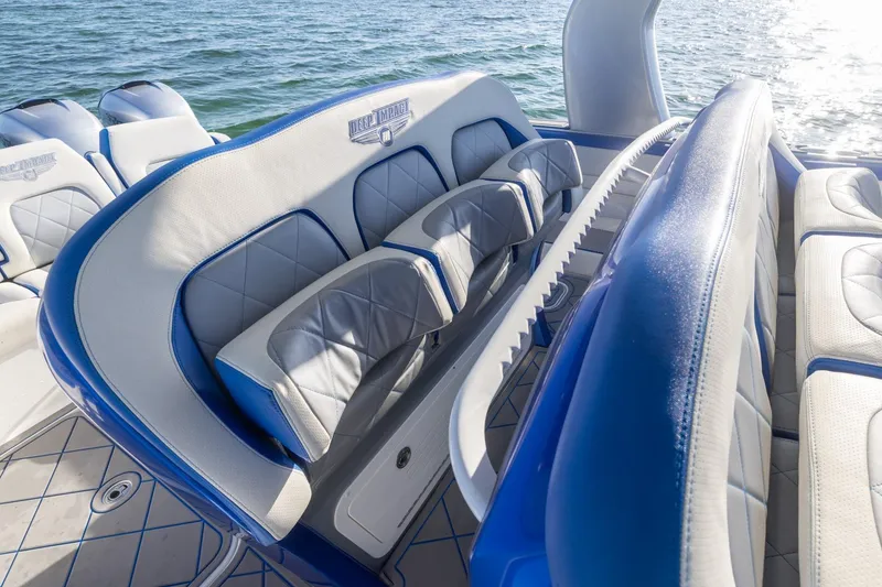 Slide: The Image of 2019 Deep Impact 399 Sport boat interior with blue and white seating, on water. - 25