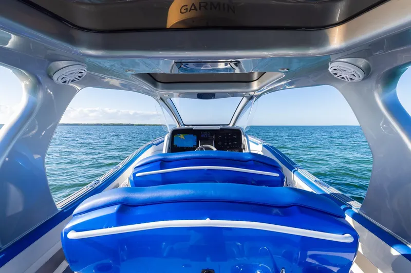 Slide: The Image of Interior view of 2019 Deep Impact 399 Sport boat with blue seating and ocean backdrop. - 27