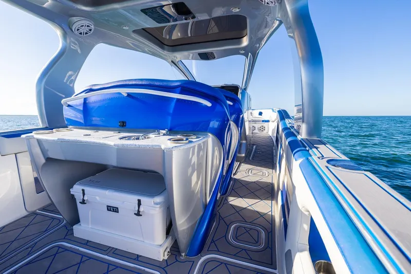 Slide: The Image of 2019 Deep Impact 399 Sport boat interior with blue seating and ocean view. - 30
