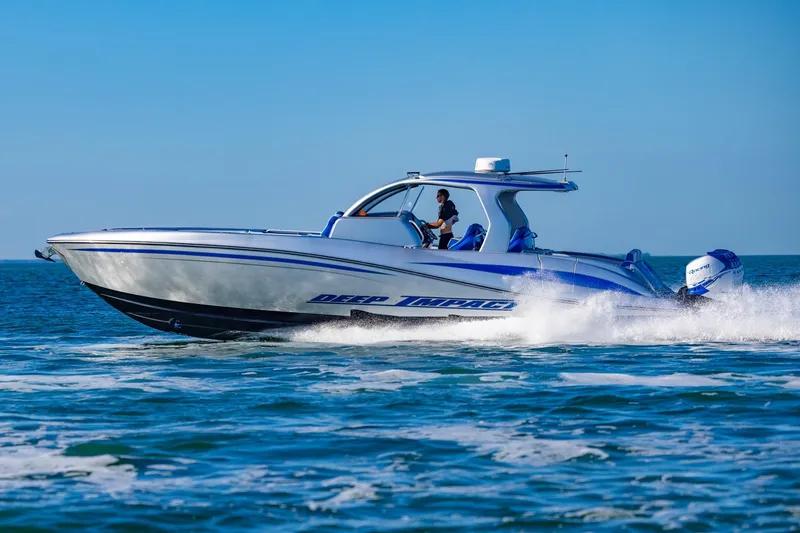 Slide: The Image of 2019 Deep Impact 399 Sport boat cruising on open water under clear blue sky. - 44
