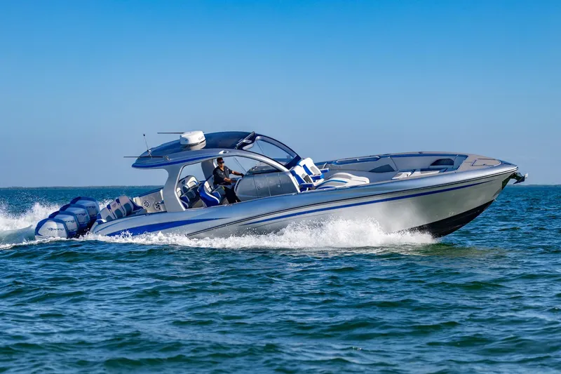 Slide: The Image of 2019 Deep Impact 399 Sport boat cruising on open water, under clear blue sky. - 49
