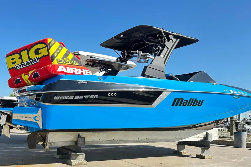 The Image of 2019 Malibu Wakesetter 24 MXZ boat with Big Mable inflatable, docked under clear blue sky. - 0