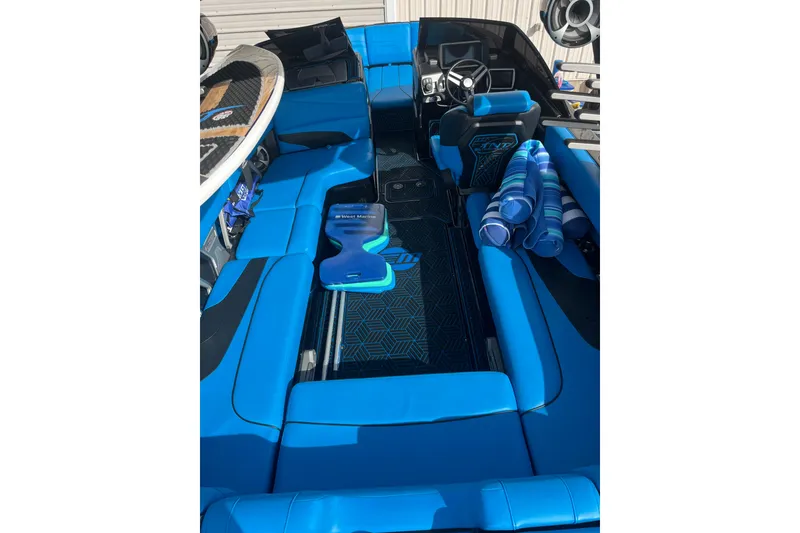 Slide: The Image of 2019 Malibu Wakesetter 24 MXZ interior with blue seating and surfboard. - 2