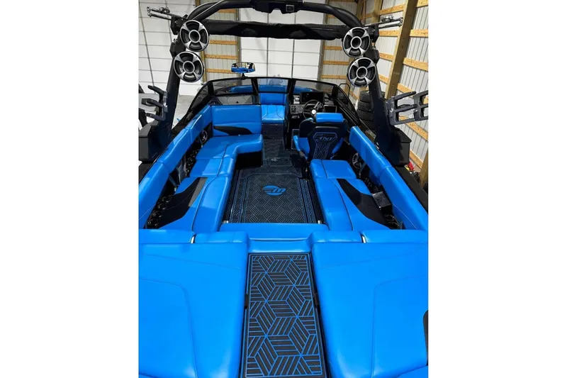 Slide: The Image of 2019 Malibu Wakesetter 24 MXZ interior with vibrant blue seating and advanced audio system. - 21