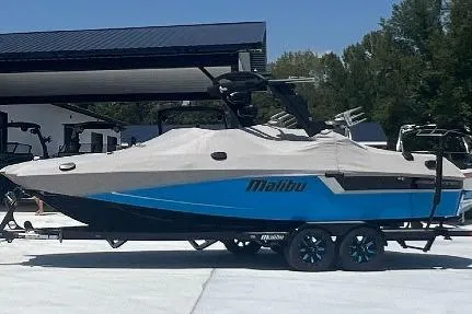 Slide: The Image of 2019 Malibu Wakesetter 24 MXZ boat with cover, parked on a trailer. - 25