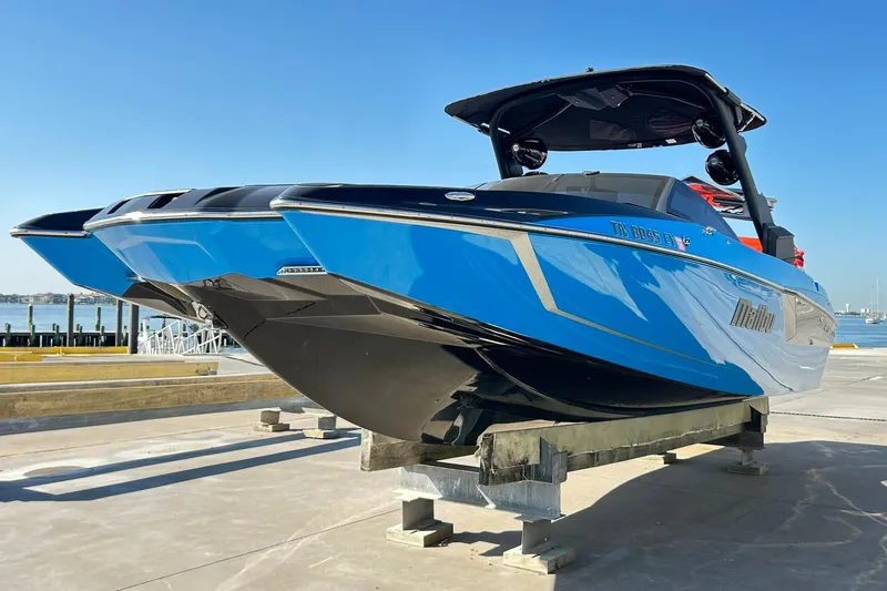 Slide: The Image of 2019 Malibu Wakesetter 24 MXZ boat in vibrant blue on a dock. - 4