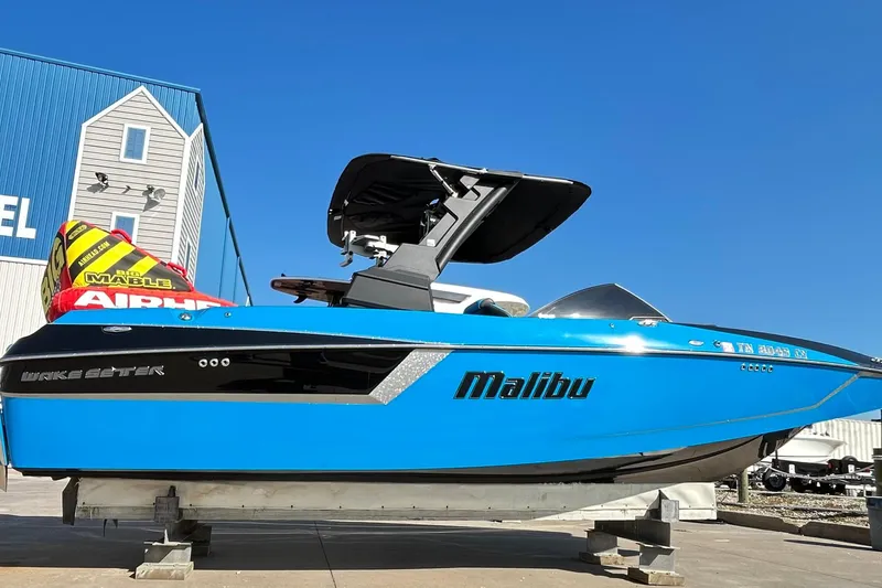 Slide: The Image of 2019 Malibu Wakesetter 24 MXZ boat in vibrant blue, displayed outdoors. - 5