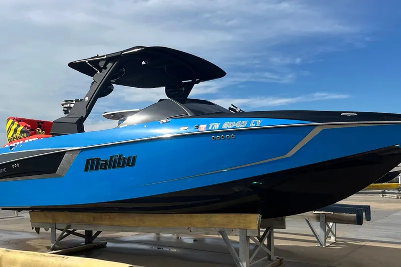 Slide: The Image of 2019 Malibu Wakesetter 24 MXZ boat in vibrant blue on a dock under clear skies. - 6