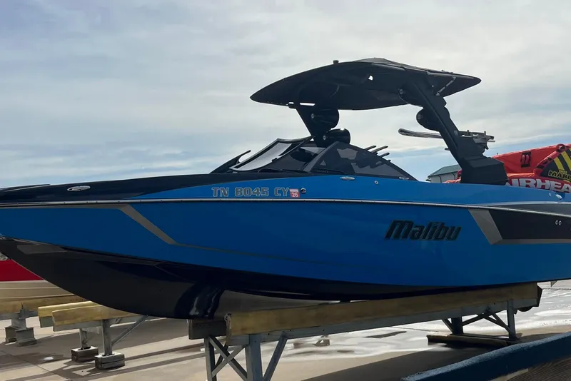 Slide: The Image of 2019 Malibu Wakesetter 24 MXZ boat in blue, displayed on a dock. - 7