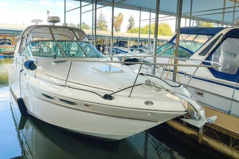 The Image of 1999 Sea Ray 290 Sundancer docked in a marina, showcasing sleek design and modern features. - 0