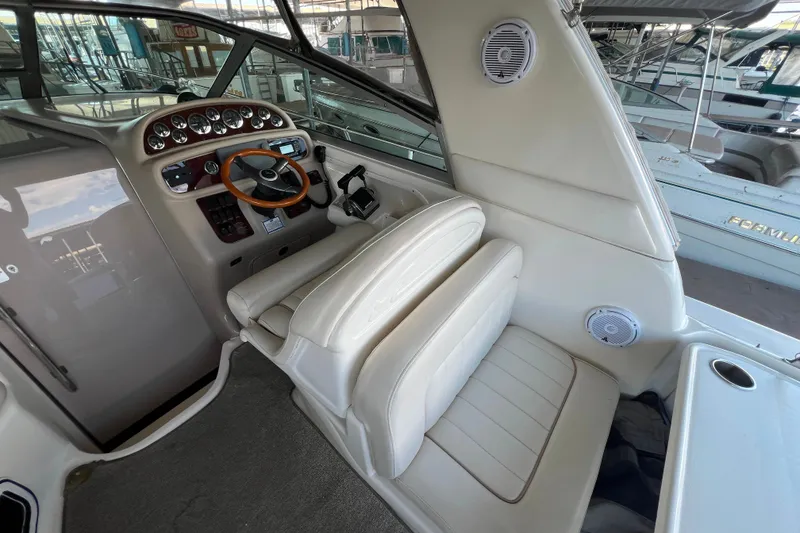 Slide: The Image of 1999 Sea Ray 290 Sundancer helm with steering wheel and control panel. - 10