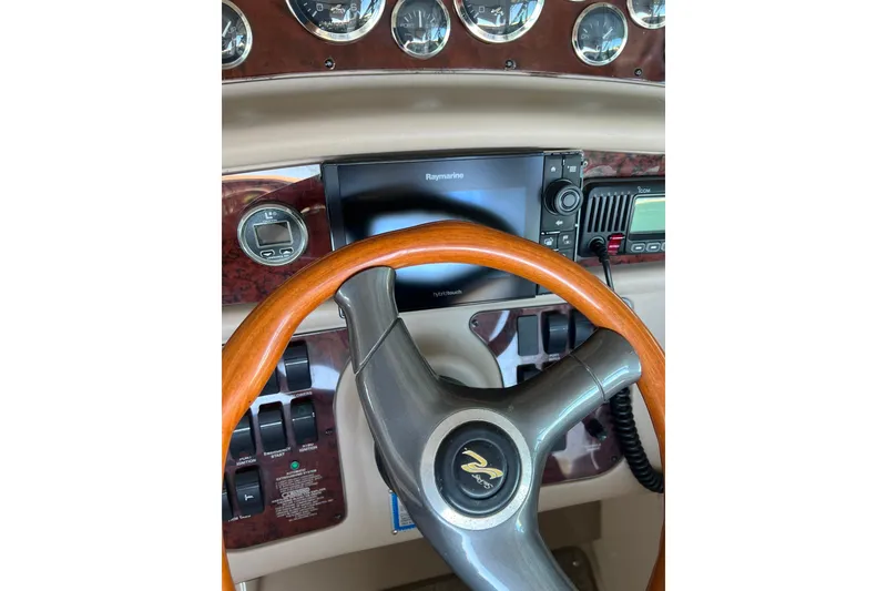 Slide: The Image of Steering wheel and dashboard of 1999 Sea Ray 290 Sundancer boat with navigation equipment. - 13