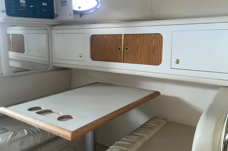 Slide: The Image of 1999 Sea Ray 290 Sundancer cabin interior with table and storage cabinets. - 27