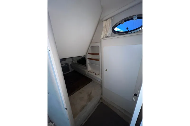 Slide: The Image of Interior cabin of 1999 Sea Ray 290 Sundancer with window and seating area. - 29