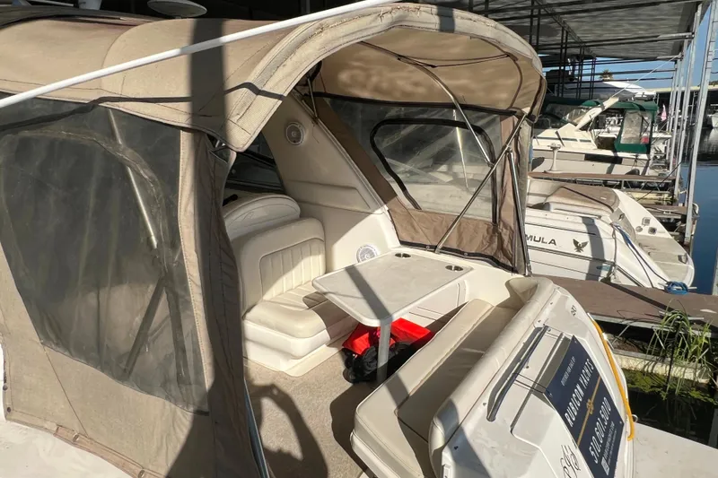 Slide: The Image of 1999 Sea Ray 290 Sundancer boat with beige canopy docked at marina. - 4