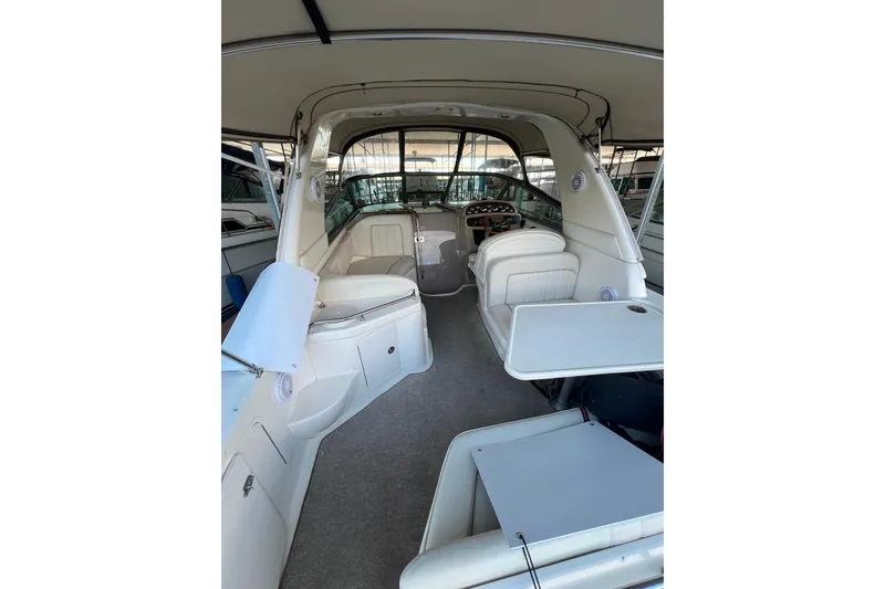 Slide: The Image of 1999 Sea Ray 290 Sundancer interior with seating and helm, showcasing spacious design. - 9