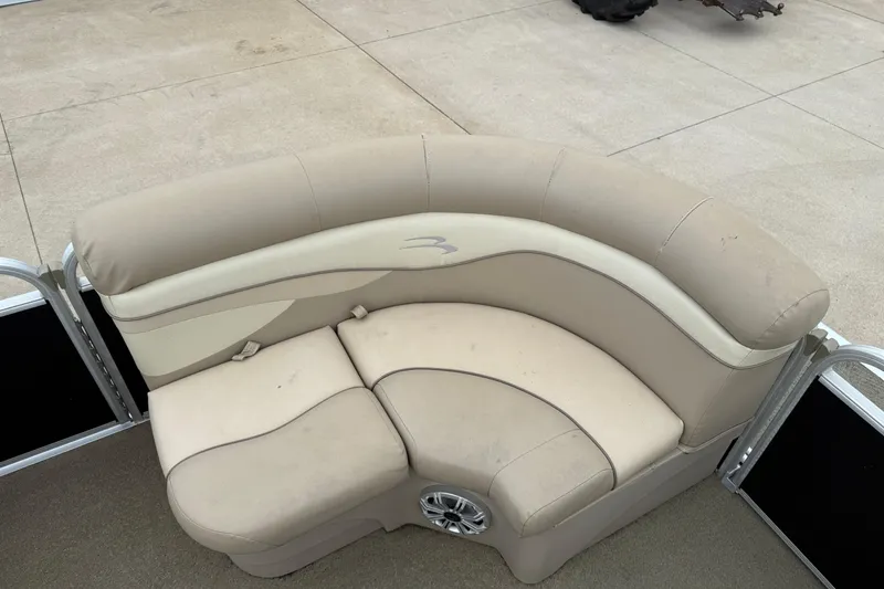 Slide: The Image of 2015 Bennington 18 SLX boat seating with beige upholstery and integrated speaker. - 14