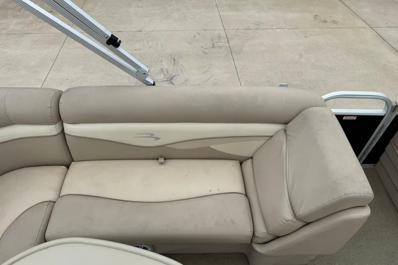Slide: The Image of Beige seating on 2015 Bennington 18 SLX pontoon boat, outdoor setting. - 18
