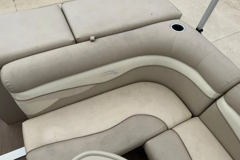 Slide: The Image of 2015 Bennington 18 SLX boat seating with beige upholstery and cup holder. - 24