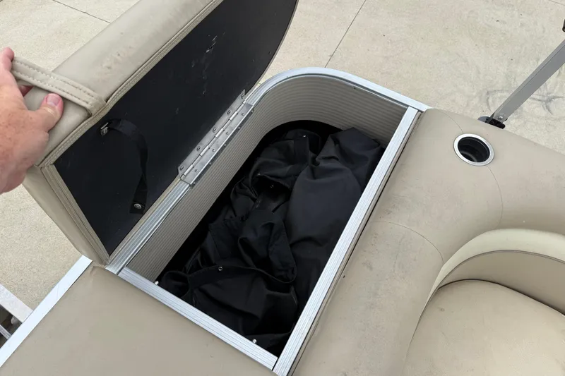 Slide: The Image of 2015 Bennington 18 SLX boat seat storage compartment with black cover inside. - 25